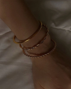 Three-piece stackable 18k gold plated stainless steel wave and twist bangles on wrist