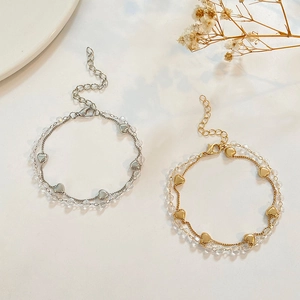 Detalle de una pulsera de doble capa con corazones, cuentas de cristal y cierre de langosta
