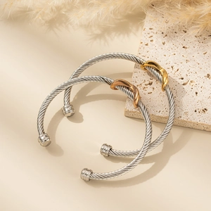 Two-piece set of twisted stainless steel cable bracelets with gold and rose gold knot accents