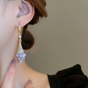 Detail showing elegant violet crystal flower earrings with sparkling leaf accents