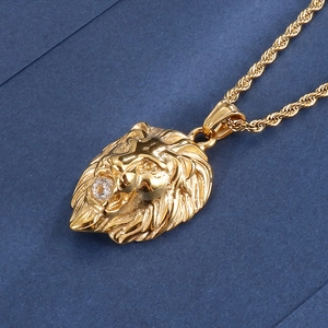 Détail du pendentif tête de lion dorée orné d'une pierre précieuse sur une chaîne