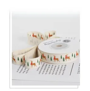 Close-up of Christmas polyester ribbon with reindeer and pine tree patterns on roll