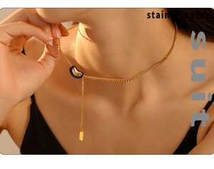 Close-up of golden stainless steel necklace with blue lucky bean pendant on neck