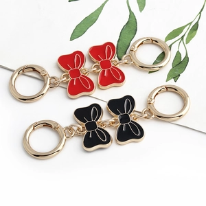 Detail of red and black metal bow chain extenders with gold spring clasps for handbags