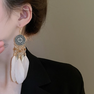 Detail view of Bohemian long feather earrings with retro beads and metal hollow patterns