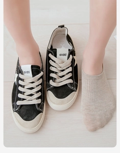 Close-up of low-cut beige cotton invisible socks paired with stylish canvas sneakers