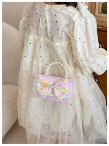 Detail of pink girls mini bag featuring sequins bow, pearl handle and lace trim