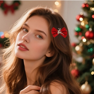 Close-up of red velvet Christmas bow hair clip with silver reindeer on girl's hair