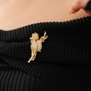 Detail of vintage golden horse brooch with white zirconias on black knit sweater