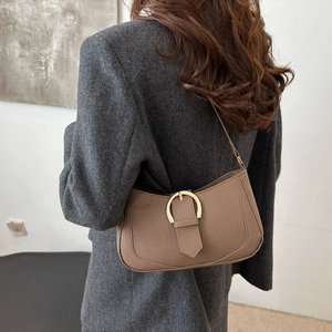 Detail of khaki crescent underarm bag with lychee texture and golden metal buckle