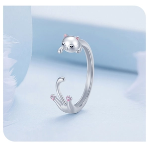 Detail of s925 silver cat ring with pink accents on soft blue and feather background