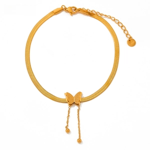 Macro detail of gold butterfly anklet with snake chain and S.STEEL material engraving