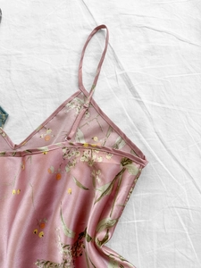 Détail de nuisette en satin rose à fleurs avec fines bretelles et décolleté en V