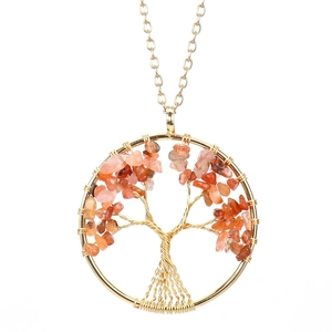 Macro detail of handmade gold wire tree of life pendant with red crystal stones