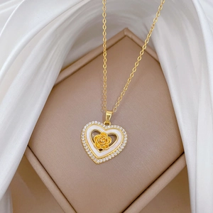Luxurious gold heart rose necklace with crystals on white silk background