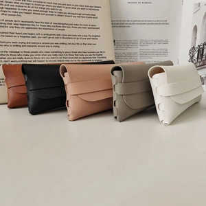 Set di cinque custodie per occhiali minimaliste in ecopelle in toni neutri su rivista