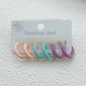 Three pairs of colorful stainless steel hoop earrings in pink, teal, and purple enamel