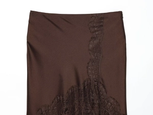 Détail de la jupe en satin marron foncé avec dentelle délicate et texture de soie lisse