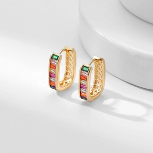 Macro view of gold rectangular hoop earrings with colorful baguette-cut rainbow zircon stones