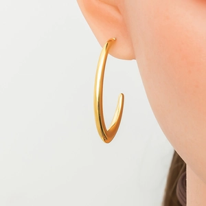 Detailed view of large 18K gold plated C-shaped hoop earring on model for jewelry display
