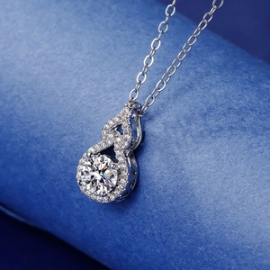 Macro detail of a 2-carat round stone pendant with halo diamond setting on a silver chain