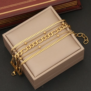Detailed view of 5-piece gold stainless steel chain bracelet set on jewelry box