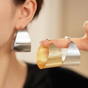 Chunky geometric hoop earrings with textured gold and silver finish for a luxury look
