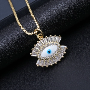 Macro shot of gold Evil Eye pendant featuring blue pupil and sparkling zircon stones