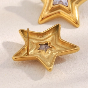 Macro shot of 18K gold plated star earrings with purple zircon and metal details