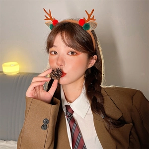 Detail of Christmas reindeer antler headband with festive ornaments worn by a model