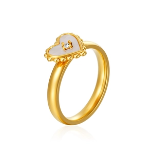 Detail of 18K gold heart ring with shell inlay and a small central zircon accent