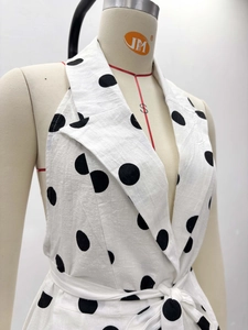 Detailed view of polka dot vest with large lapel and waist tie fastening on mannequin