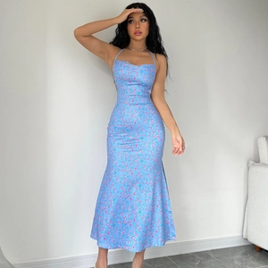 Detail view of sky blue floral dress featuring a halter neck and ruffled bodice design