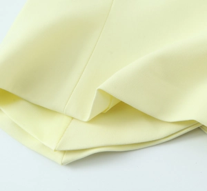 Makroaufnahme der hellgelben Köperstoff-Textur für Damen Neckholder-Top und Hose