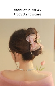 Detail of pink organza bow hair claw with gold leaves and delicate pearl tassel