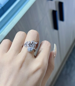 Close-up of silver leaf and teardrop ring with pavé-set zircons on woman's finger