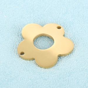Golden flower-shaped stainless steel jewelry pendant with hollow center on blue background