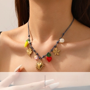 Detail of bohemian woven necklace featuring gold sun heart and colorful floral charms