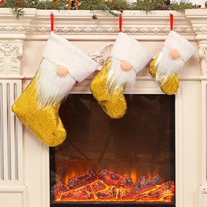 Three sequined Christmas stockings with gnome plush beard hanging on a white fireplace