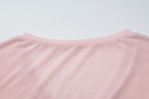 Detail of light pink ribbed neckline and soft fabric texture on summer long sleeve top