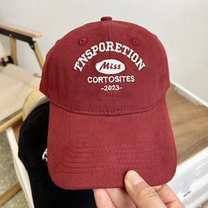 Detailed embroidery on a burgundy canvas baseball cap featuring white inspiration text