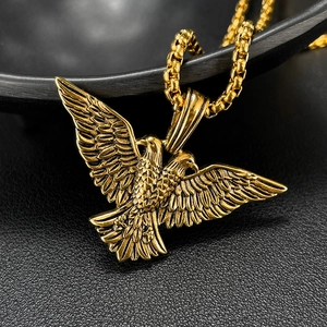Close-up of golden eagle pendant necklace showing intricate wing feather texture