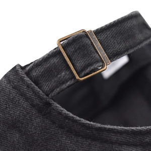 Close-up of adjustable metal buckle and corduroy fabric strap on a baseball cap