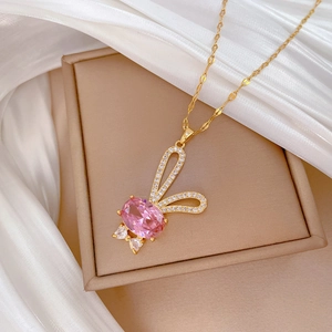 Collier pendentif lapin rose doré avec pierre ovale et cristaux sur fond de soie