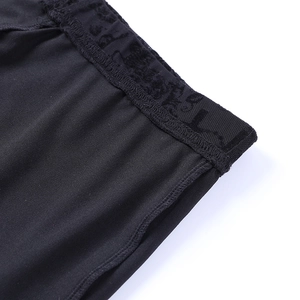 Detailed close-up of high-elastic black lace waist and seamless stitching on flared pants