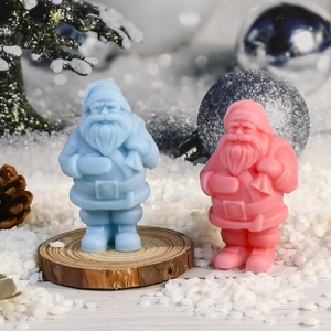 Detailaufnahme von blauen und rosa Weihnachtsmann-Kerzen auf festlichem Holzsockel