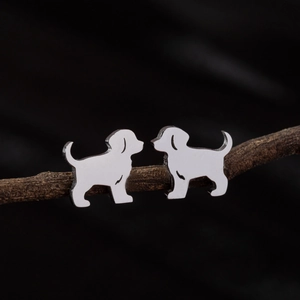 Polished silver-tone stainless steel puppy silhouette stud earrings on a branch