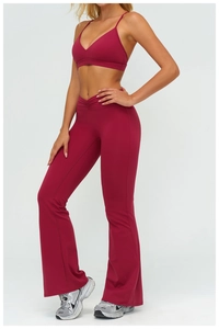 Dettaglio del set yoga bordeaux con reggiseno incrociato e leggings a campana