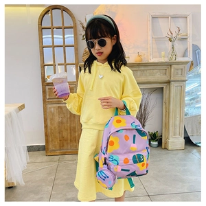 Girl wearing a purple floral nylon backpack with matching round coin purse detail