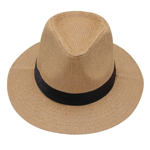 Détail de la texture en paille tressée et du ruban noir sur un chapeau Fedora marron clair